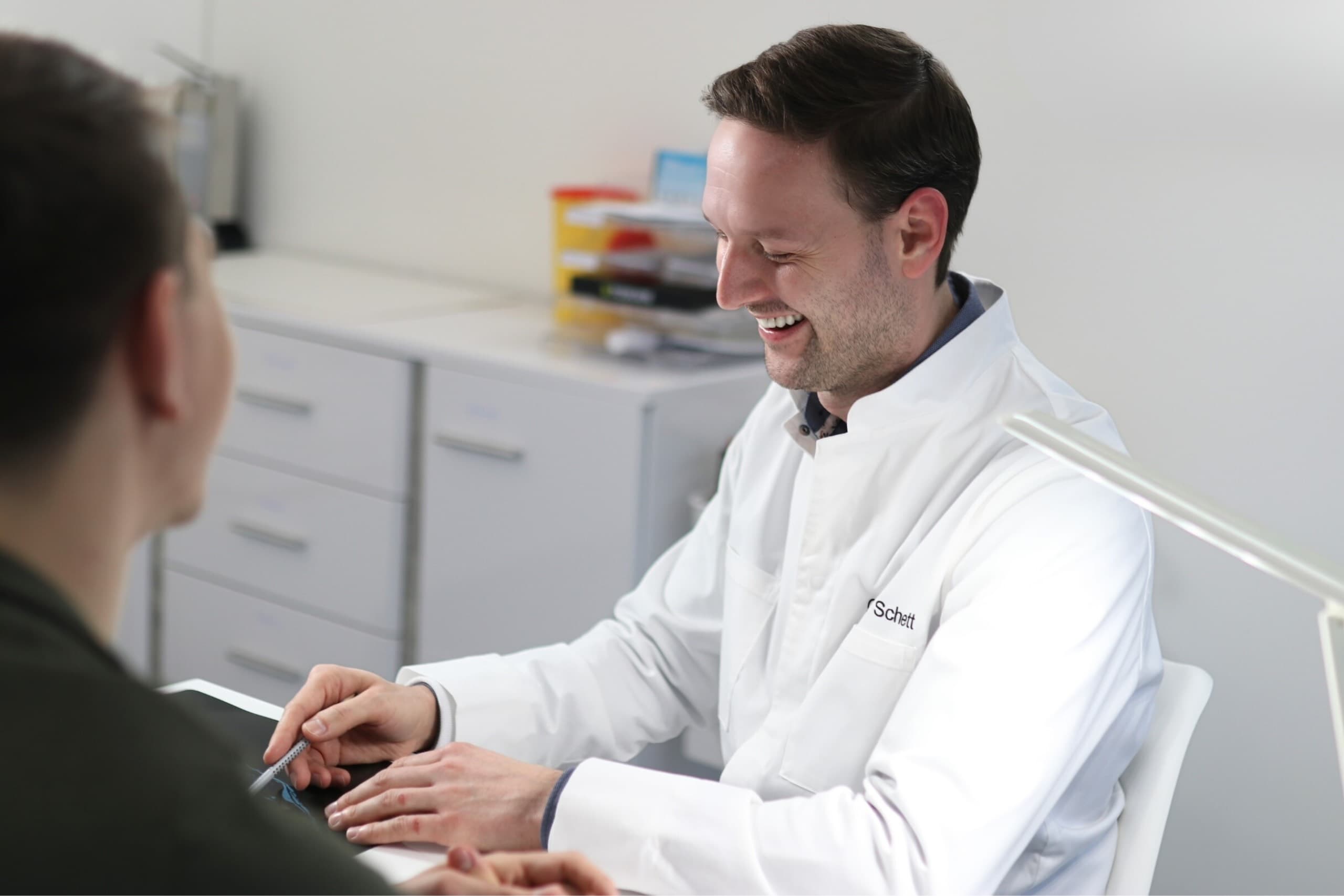 Dr. Schett im freundlichen Gespräch mit Patient